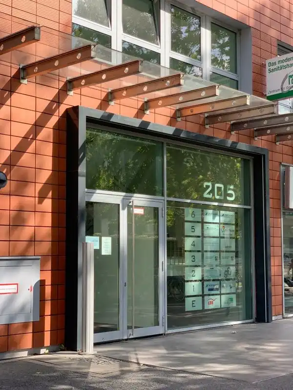 Entrance to Bonner Straße 205, a glass door with the house number and the floor directory beside it